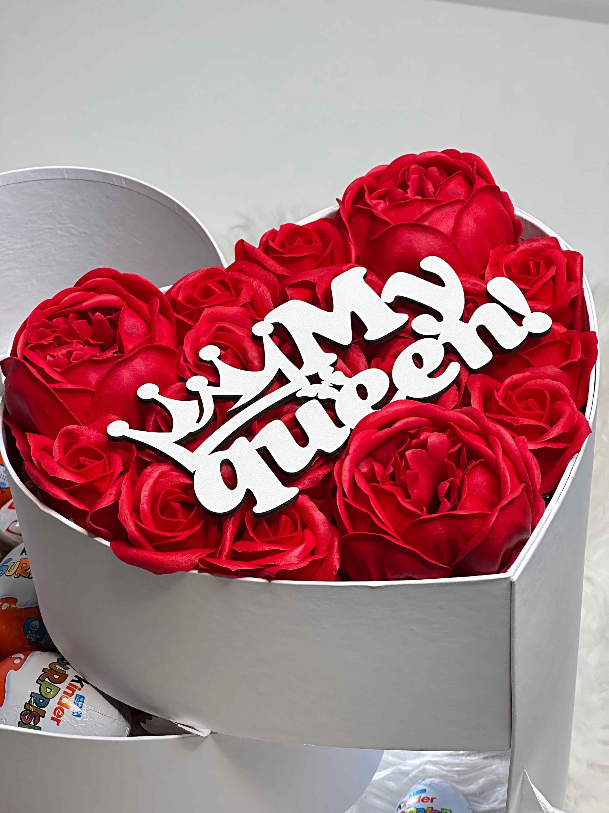 Close-up of Raffaello candies and Kinder chocolates arranged in the elegant three-tiered white gift box, combining sweetness and sophistication.